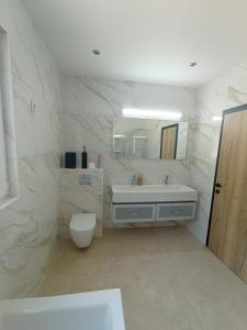 a white bathroom with a sink and a toilet at La Villa les pieds dans leau in Comblain-au-Pont +46 photos