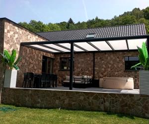 a patio with awning on a house at La Villa les pieds dans leau in Comblain-au-Pont