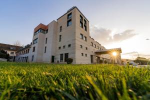 a building with a grass field in front of it at Hotel Antequera Hills in Antequera