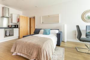 a bedroom with a bed and a kitchen at Belfry Quarters, Redhill in Redhill
