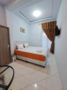 um quarto com uma cama e uma janela em Guguak Puro Guest House em Padangpanjang