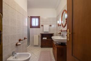 y baño con lavabo, aseo y espejo. en [10 Min Spiaggia] Moderno Bilocale con Giardino, en Porto San Paolo