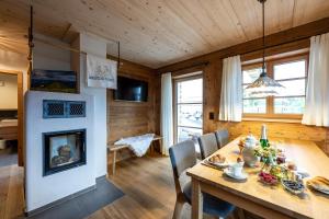 een eetkamer met een tafel en een open haard bij Waldchalets & Ferienwohnungen Allgäu in Burgberg