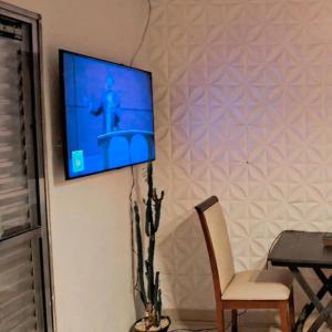 TV a parete con sedia e tavolo di Minha casa sua casa completa a Guarulhos