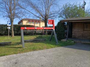 a red bench sitting in the grass next to a building at Balabuska Rooms in Codevigo