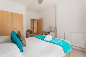 a bedroom with a large white bed with blue sheets at Castle Haven Apartment, Redhill in Redhill