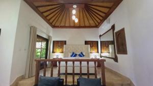 Cette chambre comprend un lit et un plafond en bois. dans l'établissement Matahari Inn Kuta Lombok, à Kuta Lombok
