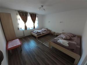 a small room with two beds and a window at Cabana Colț de Rai in Arieşeni