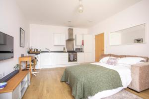 a living room with a bed and a kitchen at Queens Lodge, Redhill in Redhill