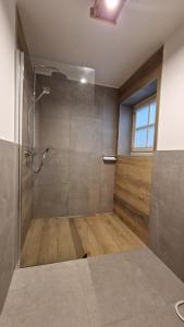 baño con ducha y puerta de cristal en Appartamento Col Val di Fassa con giardino BAGNI RINNOVATI 2023, en Campitello di Fassa