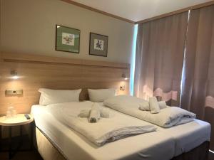 a bedroom with a large white bed with towels on it at Altes Sudhaus in Aschaffenburg