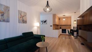 uma sala de estar com um sofá verde e uma cozinha em Apartament na Spokojnej em Wisla