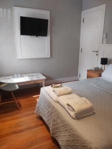 um quarto com uma cama com uma secretária e uma televisão na parede em Posada Güemes BOUTIQUE em Mar del Plata