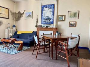 a living room with a table and a blue couch at Prieuré de la Chesnaie x Melrose in Saint-Vigor-le-Grand +25 photos