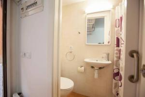 a bathroom with a toilet and a sink and a mirror at La Bella Lola Boutique Home in Palamós