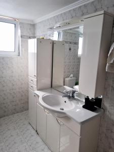 a white bathroom with a sink and a mirror at Aegean Villa in Mourteri