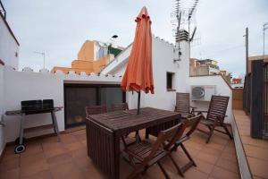 un patio con una mesa y una sombrilla en el techo en La Bella Lola Boutique Home, en Palamós