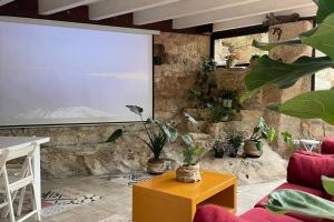 a living room with plants and a projection screen at La Morada de Creta in Aren