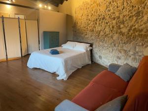 ein Schlafzimmer mit einem Bett und einer Steinmauer in der Unterkunft La Morada de Creta in Aren