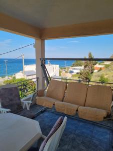 a couch on a balcony with a view of the ocean at Aegean Villa in Mourteri