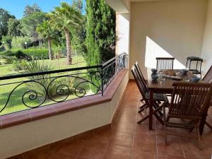 a balcony with a table and chairs and a large window at Appartement, 60m2, 6 couchages avec piscines à Marine de Bravone, Linguizetta, résidence Sognu Di mare Corse in Linguizzetta