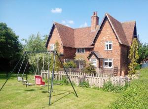 a yard with a swing set in front of a house at Flo's Cottage self-catering in Newark upon Trent