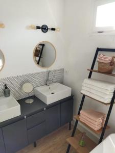 La salle de bains est pourvue d'un lavabo et d'un miroir. dans l'établissement Maison avec jardin Auxerre, à Saint-Georges-sur-Baulche