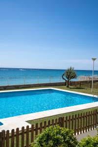 a swimming pool with the ocean in the background at Apartamentos Calpestabili in Altea