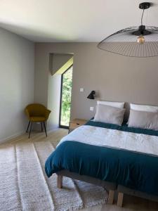 een slaapkamer met een blauw bed en een raam bij Charmante longère à 700 m de la plage in Guidel