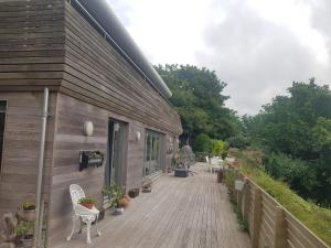 a wooden deck with chairs and a building at Powis Cottage in Laugharne