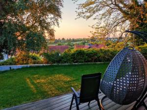 a chair on a deck with a view of a yard at Exklusives Holzhaus mit Bergbahn - Baden-Baden im Schwarzwald in Baden-Baden
