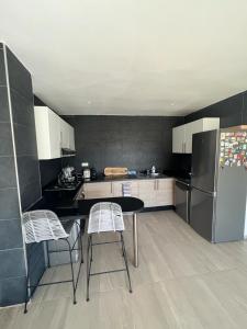 uma cozinha com uma mesa e cadeiras e um frigorífico em Bel Appartement Agadir Tamourit em Agadir