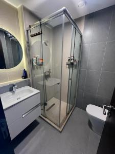 uma casa de banho com um chuveiro, um lavatório e um WC. em Bel Appartement Agadir Tamourit em Agadir