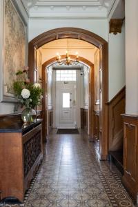un corridoio decorato con lampadario pendente e un corridoio con porta di B&B Tannerie a Balen