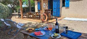 a wooden table with a bottle of wine and wine glasses at Barcarès joli mas de pêcheurs rénové classé 4 étoiles 8 couchages in Le Barcarès