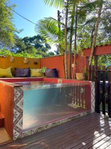 a swimming pool in a backyard with a fence and trees at Magias de Paraty Ecopousada in Paraty