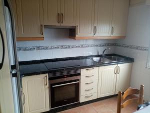 a kitchen with a sink and a stove at Casa de verano in O Grove