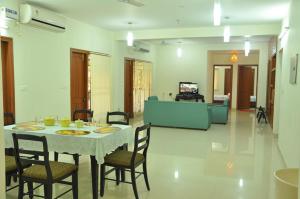a dining room with a table and chairs in a room at Phoenix Serviced Apartment - 14th Main Road, Anna Nagar in Chennai
