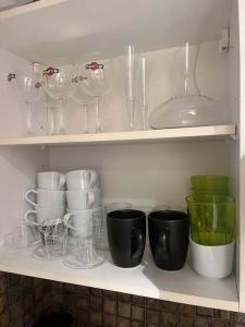 un estante lleno de vasos, tazas y platos en Studio im Herzen von Monte Carlo en Montecarlo