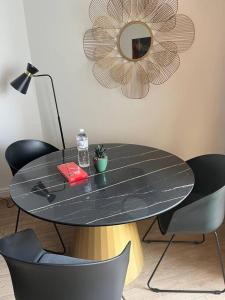 een zwarte tafel met stoelen en een spiegel aan de muur bij Studio im Herzen von Monte Carlo in Monte Carlo