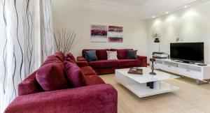 sala de estar con 2 sofás rojos y TV en Apartment APB01 Medusa, en Kouklia