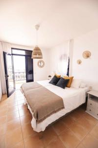 1 dormitorio con 1 cama blanca grande con almohadas amarillas en Bahía Meloneras Playa 1 en Meloneras