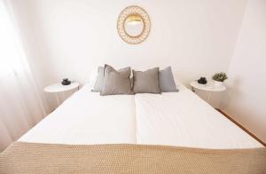 een slaapkamer met een groot wit bed en 2 tafels bij Bahía Meloneras Playa 1 in Meloneras