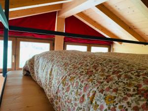 a bed in the middle of a room with windows at Comodo rifugio montano LA STAFFA in Valdidentro in Premadio