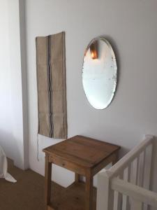 un espejo en una pared junto a una mesa de madera en Maison Blanche, en Laroque-des-Albères