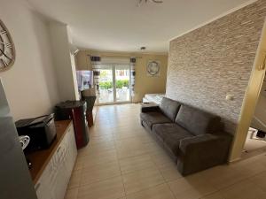 a living room with a couch and a brick wall at Holiday house Ina*** in Barbat na Rabu