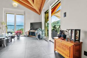 sala de estar con TV y ventana grande en Logement avec vue sur la plaine, en Troistorrents