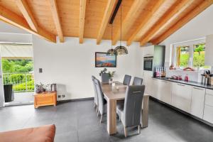 cocina y comedor con techo de madera en Logement avec vue sur la plaine, en Troistorrents