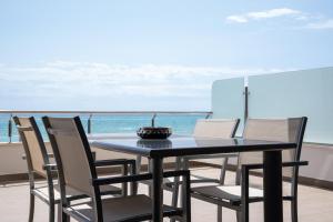 una mesa y sillas con el océano en el fondo en Apartamentos Calpestabili, en Altea