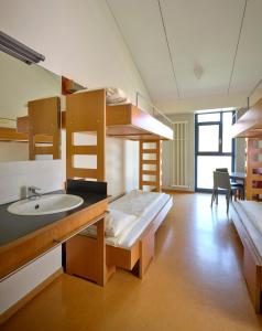 LultzhausenにあるYouth Hostel Lultzhausenの洗面台と二段ベッドが備わる客室です。